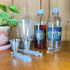 Bottle of water with bottle of honey, a glass and measuring cups on a counter